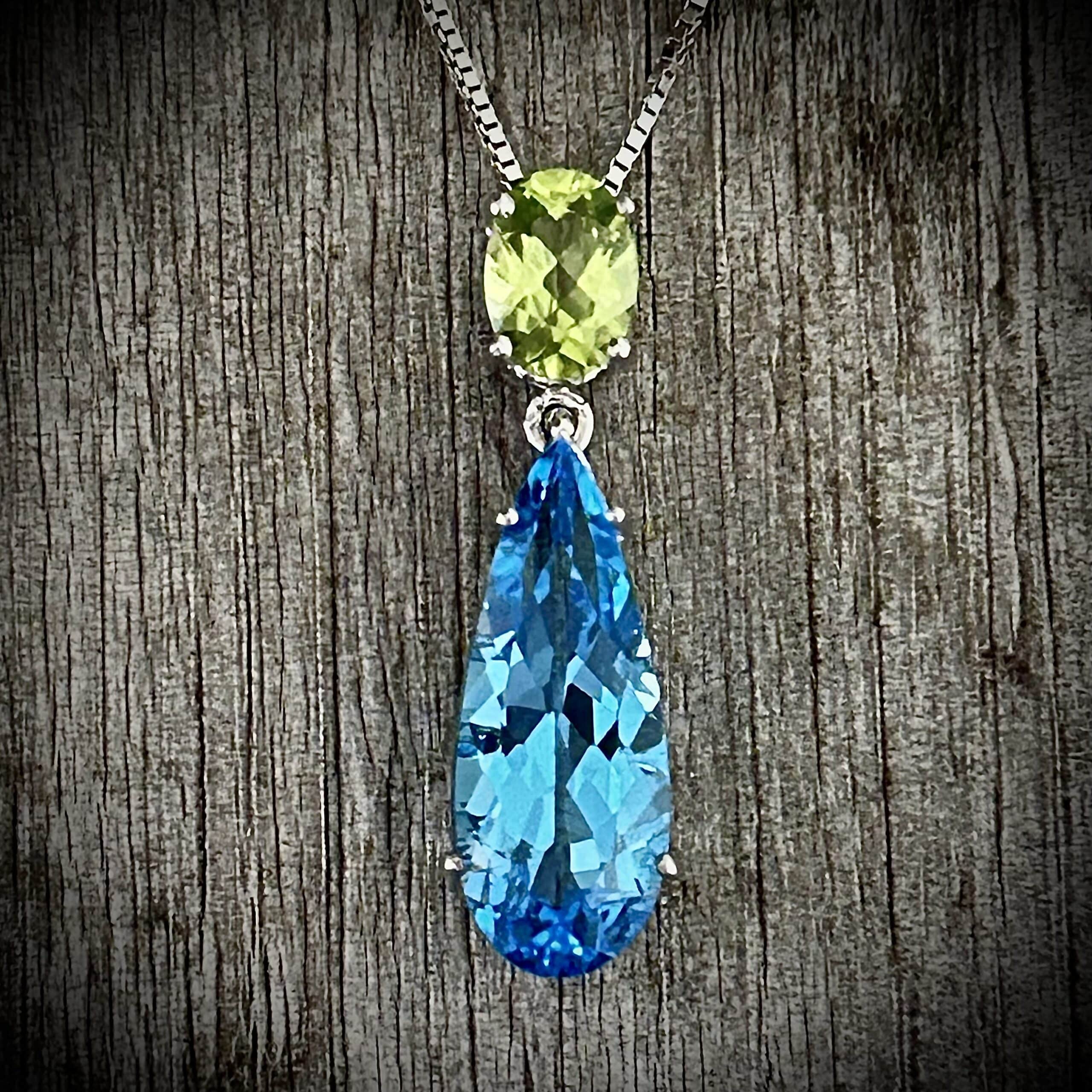 Blue Topaz And Peridot Pendant Close-Up On A Wood Background.