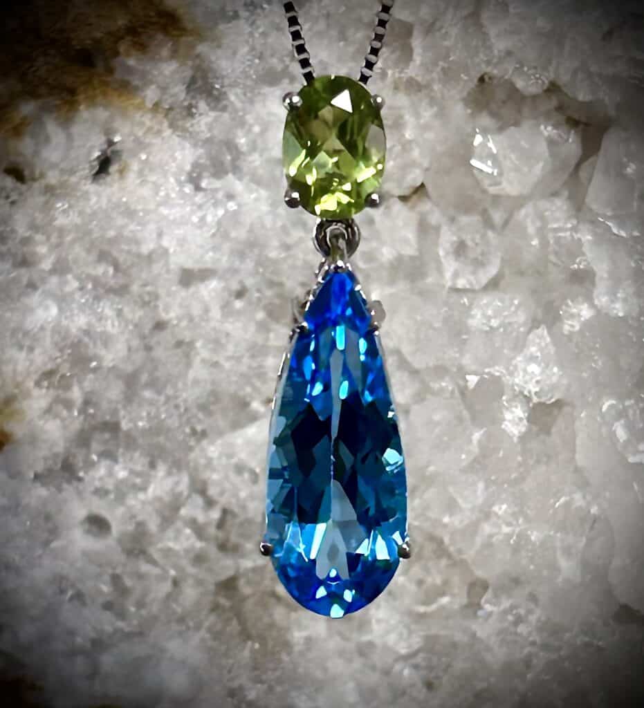 Blue Topaz And Peridot Pendant Set In A White Organic Background