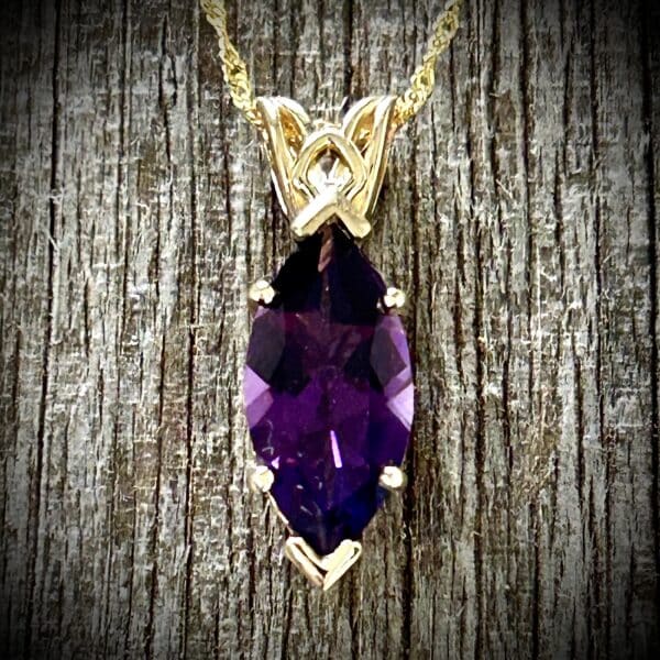 Marquise Cut Amethyst Pendant Showcasing Purple Gemstone Color And 14K Yellow Gold Scroll Design